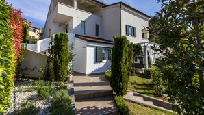 A modern two-story house with a covered patio and a landscaped garden. - Forest&Sea apartment-Bikes&table incl (Medulin)