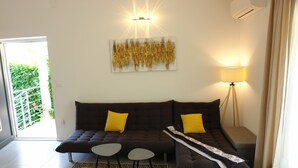 A living room with a dark brown sofa, two yellow cushions, a small round table, and a lamp. - Forest&Sea apartment-Bikes&table incl (Medulin)