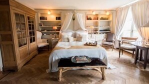 A bedroom with a canopy bed, wooden wardrobe, bedside tables, and a reading chair. - Casa Ciolina (Peer)