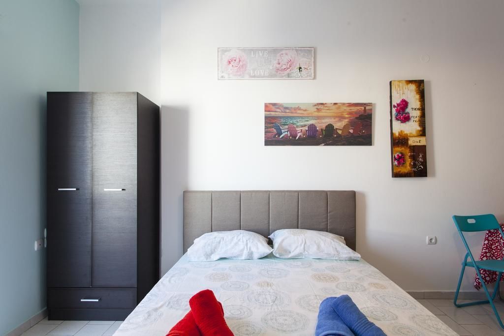 A bedroom with a bed, a wardrobe, and two wall decorations.