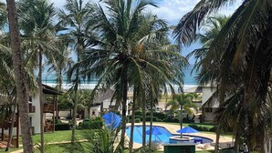 Un resort con piscina, palmeras y vistas al océano.