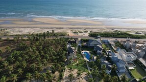 Zona residencial costera con casas, piscina y playa.