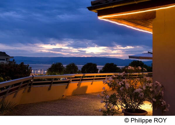 A balcony with a view of the sea and mountains during twilight. - VVF Lac Léman, Évian-les-Bains (Evian-les-Bains)