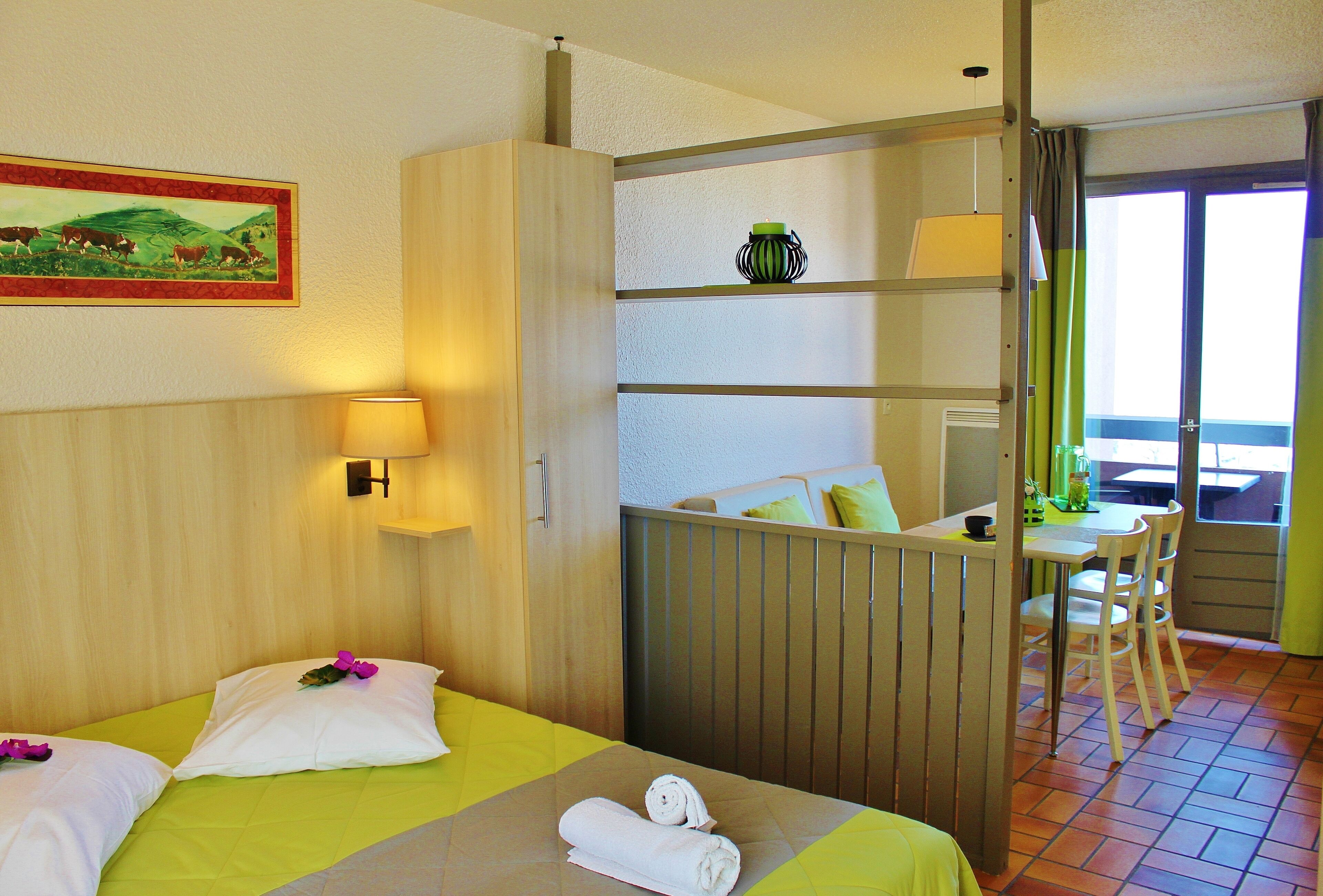 Ein Hotelzimmer mit zwei Betten, einem Essbereich und Blick ins Freie.