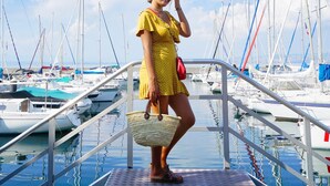 A woman in a yellow dress standing on a dock with boats in the background. - VVF Lac Léman, Évian-les-Bains (Evian-les-Bains)
