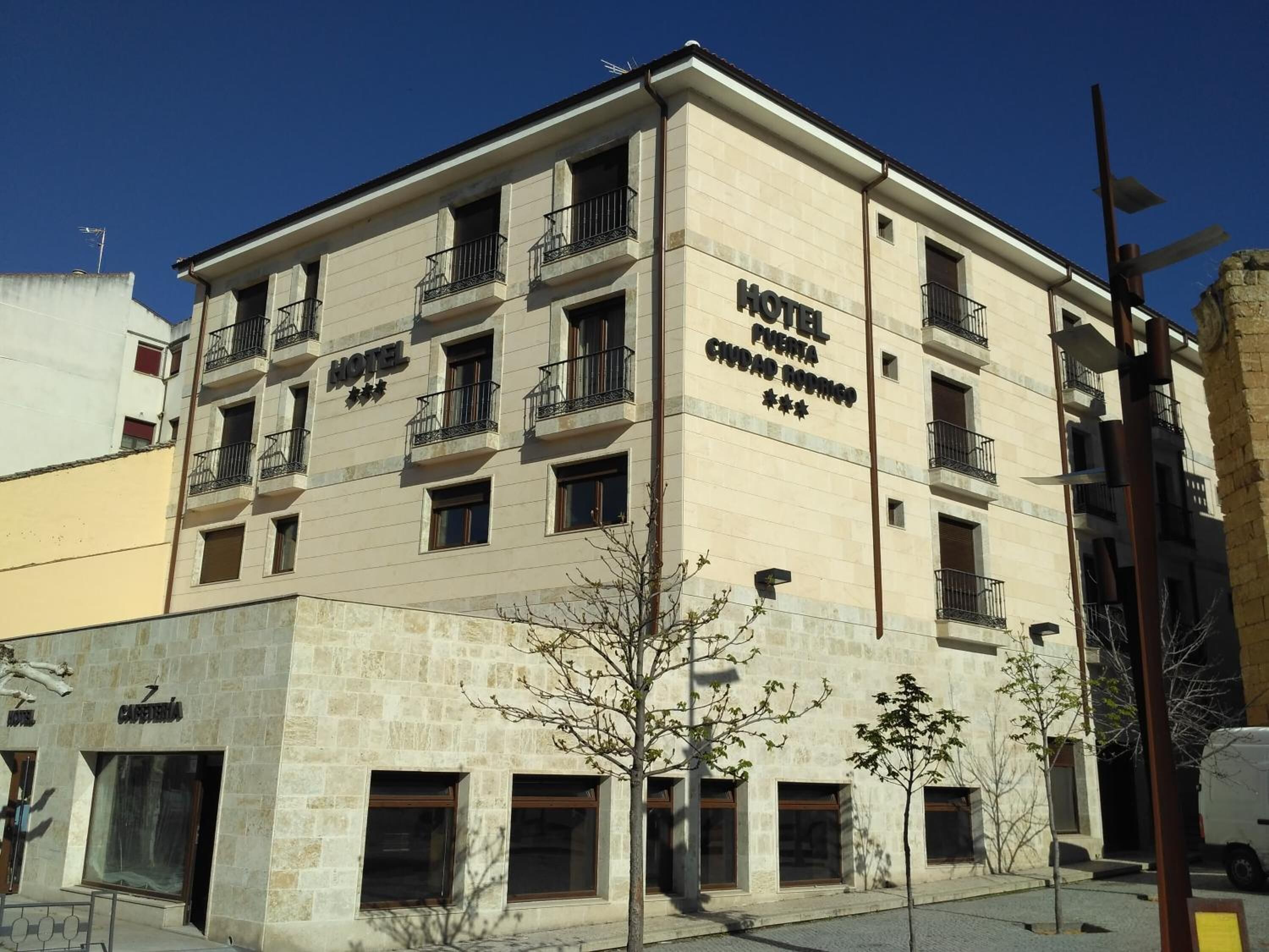 Hotel de vários andares com varandas, placa indicando ser um hotel e entrada visível.