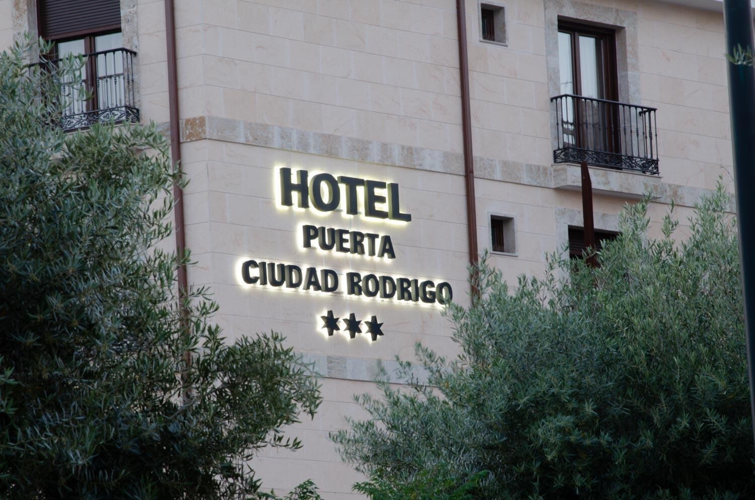 A hotel sign with the name "HOTEL PUERTA CIUDAD RODRIGO" and three stars rating.