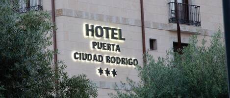 A hotel sign with the name "HOTEL PUERTA CIUDAD RODRIGO" and three stars rating.