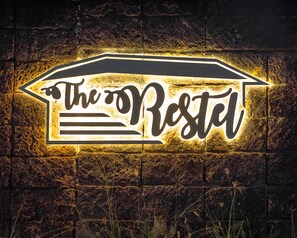 A neon sign on a brick wall with the text "The Restel". - The Restel - Hostel (Chiang Mai)