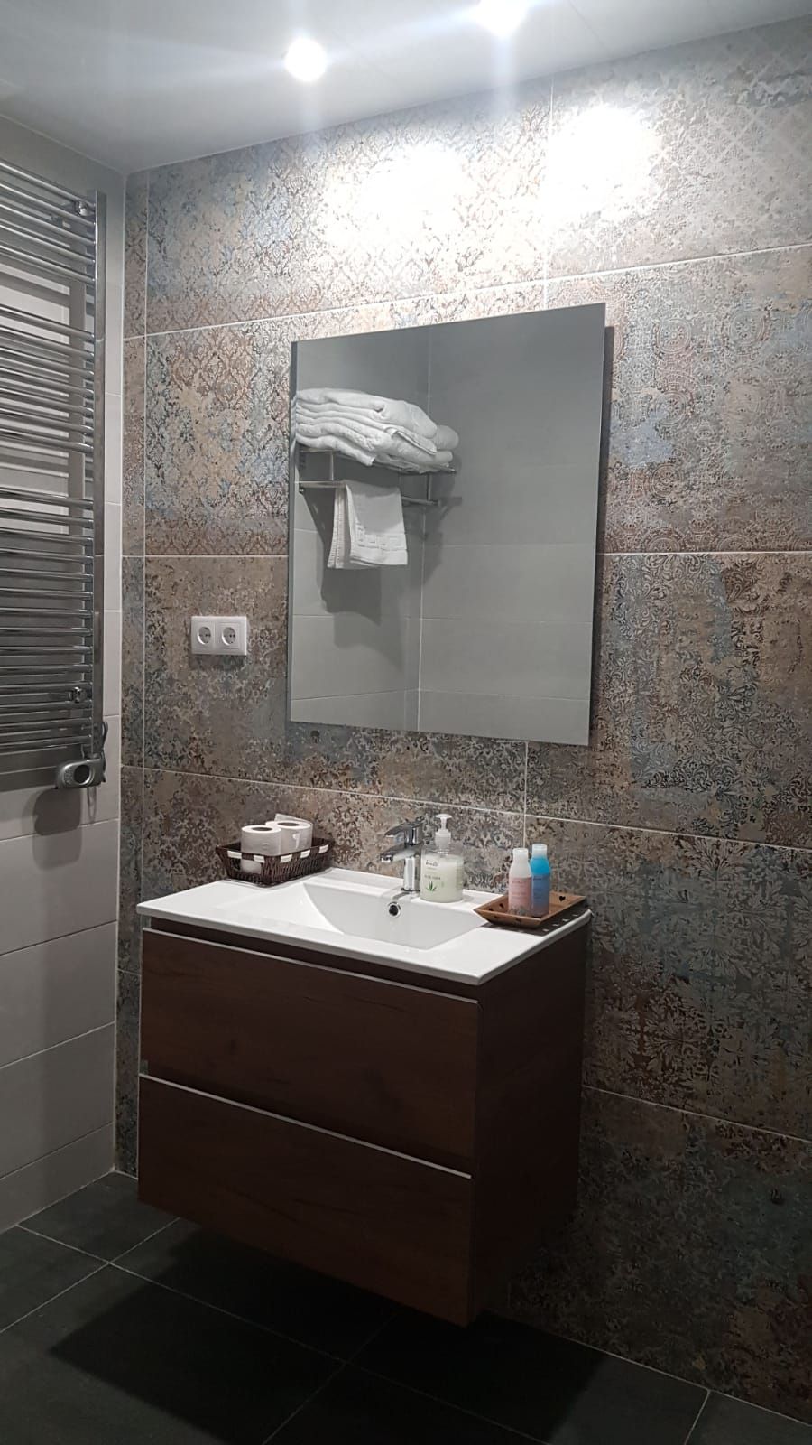 A bathroom with a vanity, a mirror, and a towel rack.