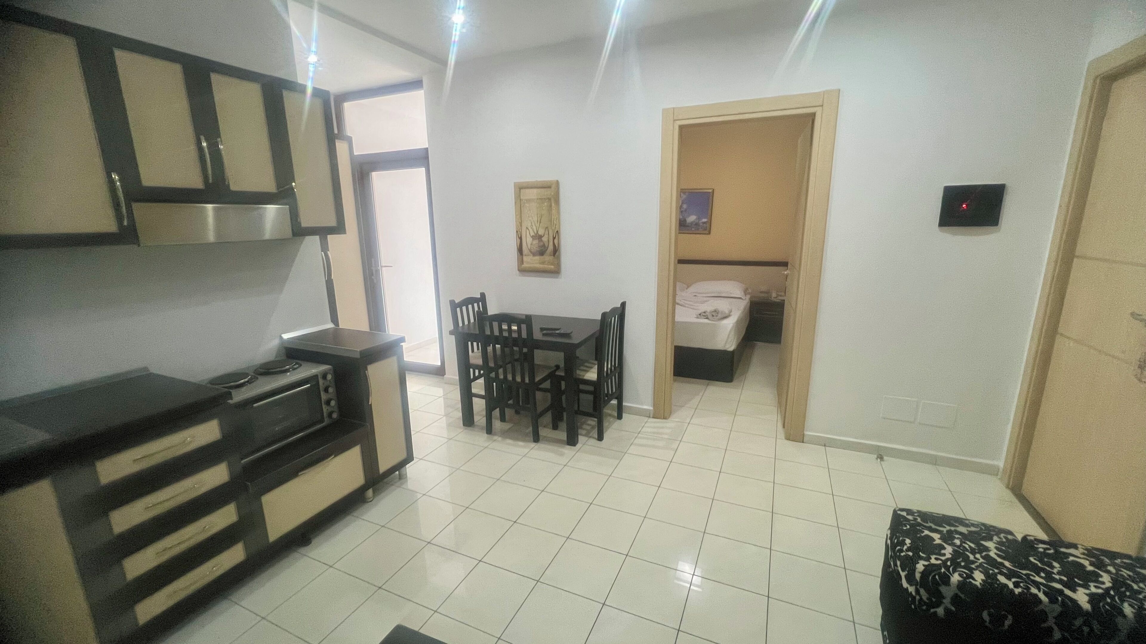 A compact living space with a kitchenette, a dining area, and a bedroom.