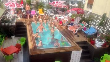 Een buitenzwembad, parasols voor strand/zwembad