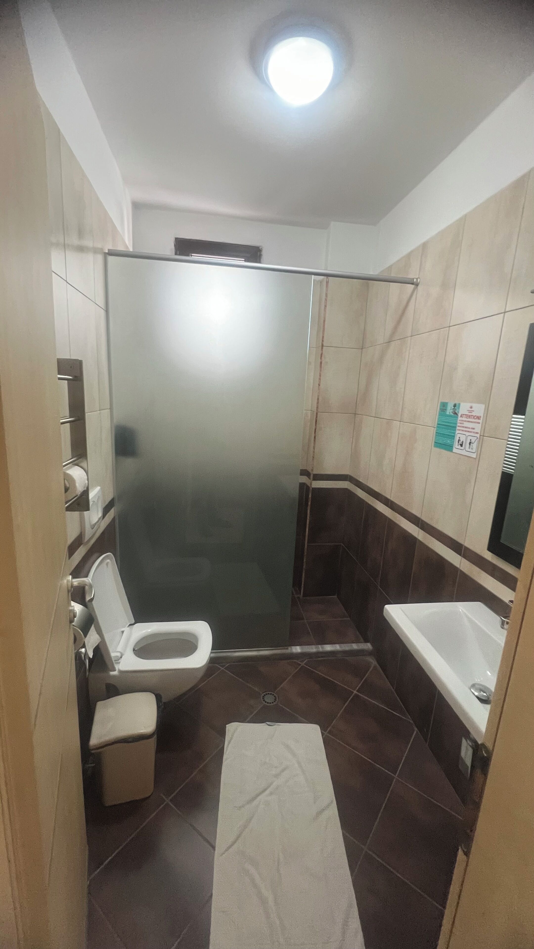 A bathroom with a toilet, a shower stall, and a sink.