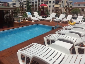 Piscine extérieure, parasols de plage, chaises longues