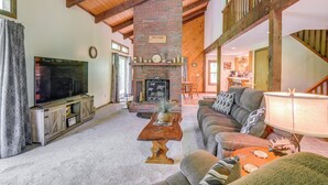 A cozy living room with a fireplace, a television, and a comfortable seating area. - New Hampshire Vacation Rental - Walk to Beach! (Madison)