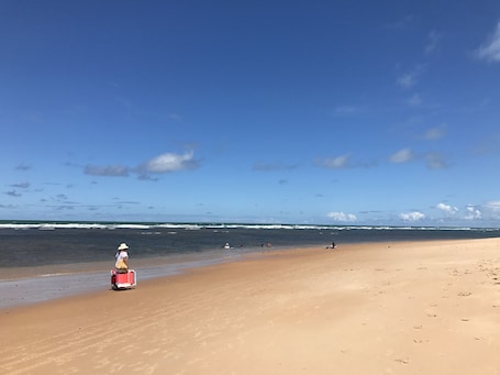 On the beach, white sand, beach umbrellas, beach towels