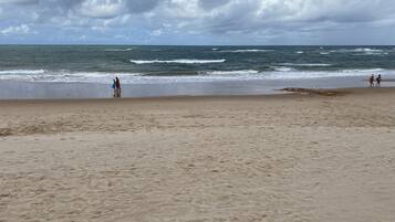 Uma praia com areia e ondas.
