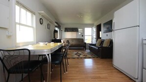 Un espace de vie compact comprenant un coin repas, un canapé et un réfrigérateur.