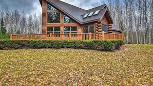 A log cabin with a large deck and multiple windows.