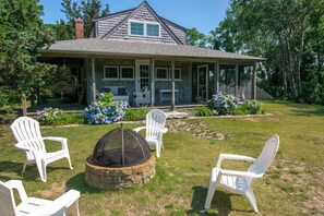A house with a covered porch, outdoor seating, and a fire pit. - Private beach access Wrap around porch! (Orleans)