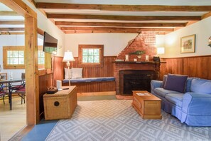 A cozy living room with a fireplace, a television, and a sofa. - Private beach access Wrap around porch! (Orleans)