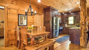 A wooden interior with a dining table, chairs, a bench, a refrigerator, and a sink. - 25-Acre Mountain Retreat w/ Trails, Pond, Hot Tub (Penrose)