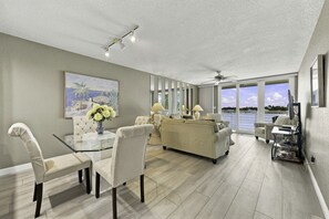 Un amplio salón con sofá, sillas, una mesa de comedor y vistas al agua.