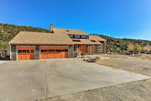 Une maison moderne à deux étages, dotée d’une grande allée, de fondations en pierre et de deux portes de garage.