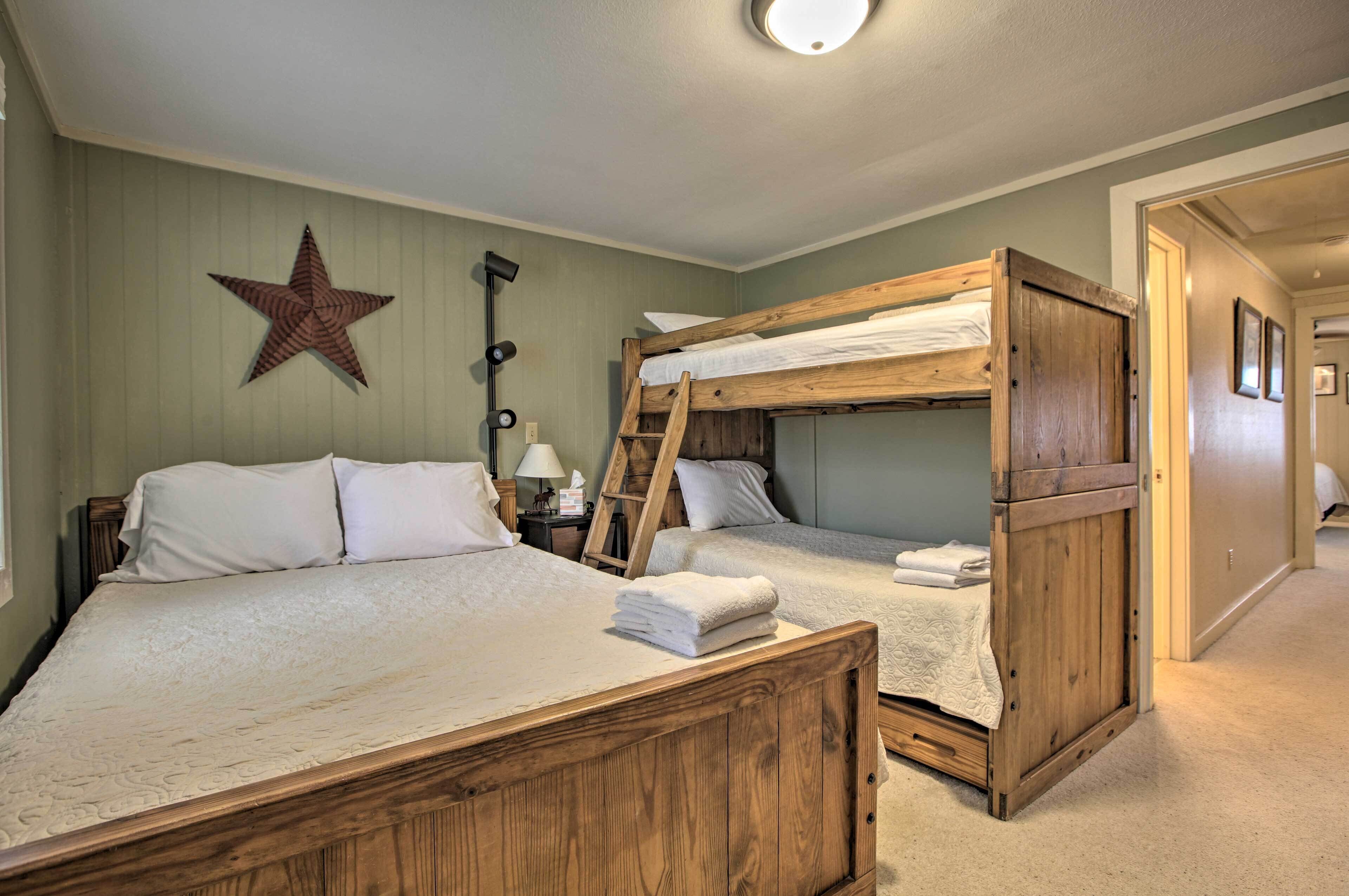 Una habitación con literas, un adorno con forma de estrella, una lámpara y una escalera.