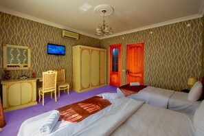 A hotel room with two beds, a desk, a TV, and a wardrobe. - Iva Old City Hotel (Baku)
