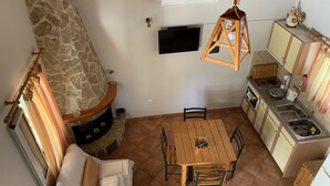 Eine gemütliche Küche mit Kamin aus Stein, einem Holzespeise Tisch und einem eingebauten Ofen.