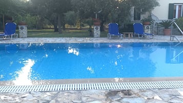 Piscine extérieure en saison, chaises longues