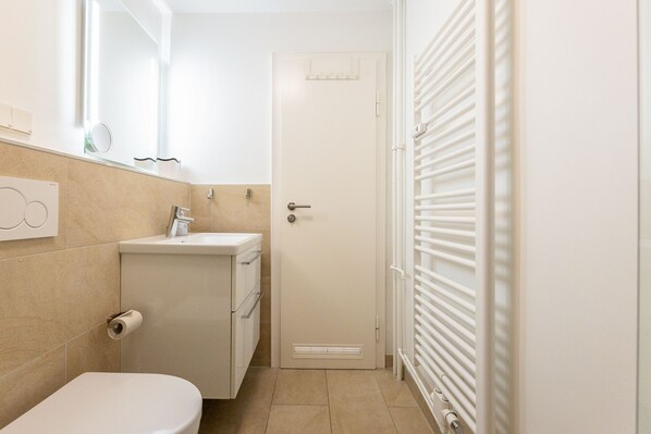 A small bathroom with a toilet, sink, and mirror. - Tüti in the Sola Bona house (Westerland)