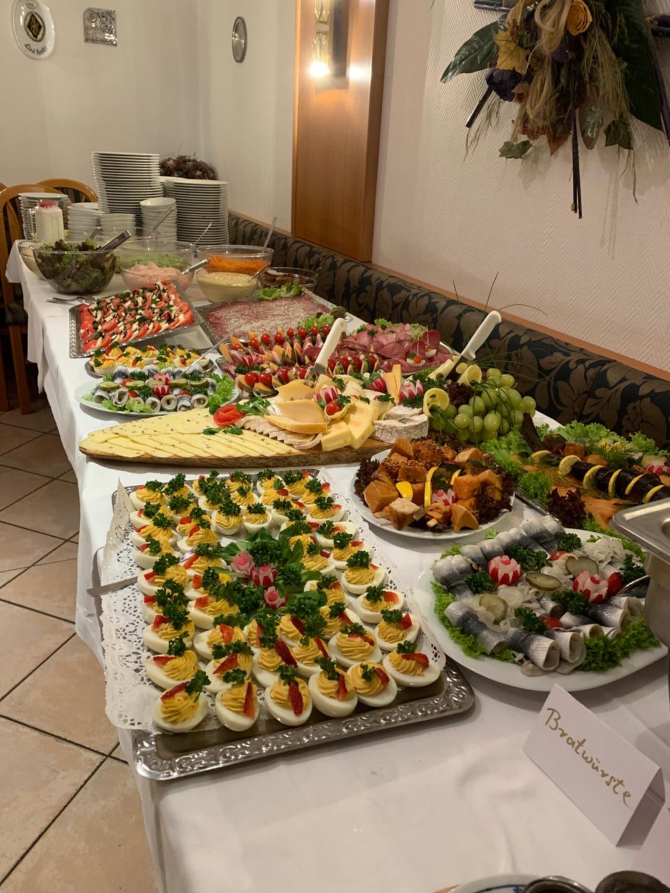 A buffet table with various food items including salads, cheeses, meats, and seafood.