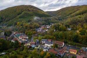 A town nestled in a valley with houses and buildings surrounded by forested hills. - Hotel - Gasthof Hüttensteinach (Sonneberg)