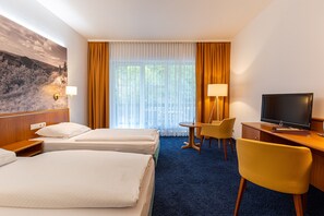 A hotel room with two beds, a desk with a television, a chair, and a lamp. - Hotel - Gasthof Hüttensteinach (Sonneberg)