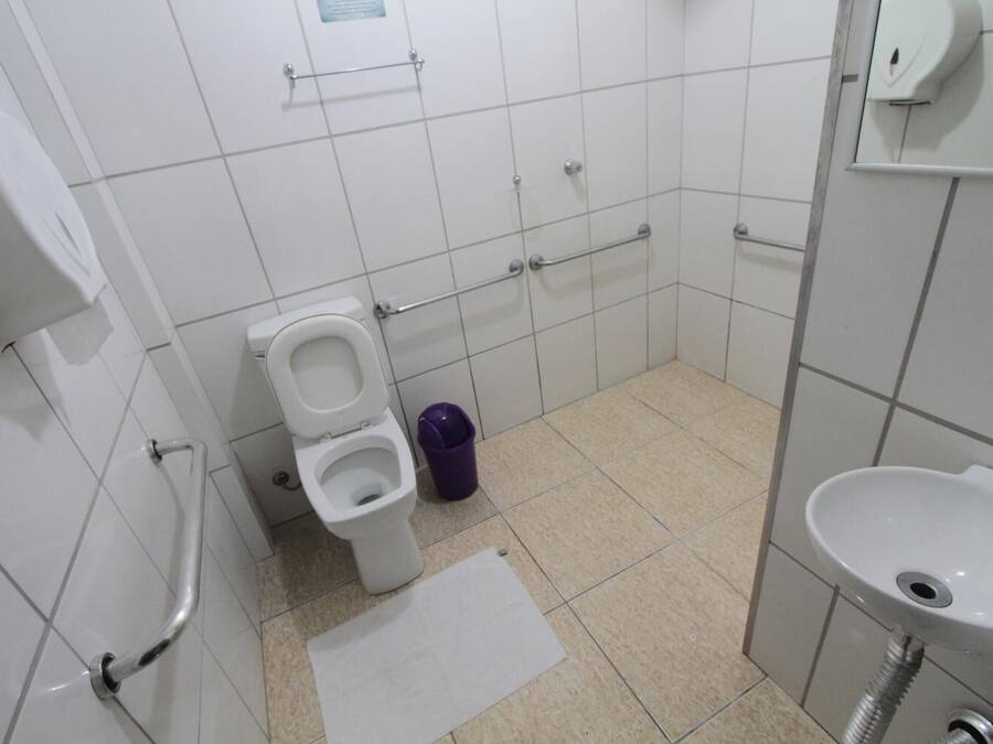 Un baño pequeño y limpio con inodoro, lavamanos y cubo de basura.