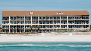 Un hôtel à plusieurs étages doté de balcons, situé près d’une plage.