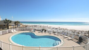 Ein Poolbereich mit Blick auf Strand und Meer.