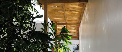 A staircase with a wooden ceiling, white walls, and a door at the top.