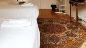 A hotel room with two beds, a ceiling fan, a television, a mirror, and a patterned rug. - Happy @ Chiado (Lisbon)
