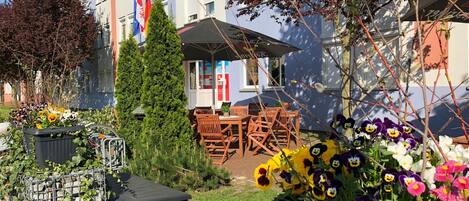 A hotel courtyard with outdoor seating, a Christmas tree, and flower arrangements.