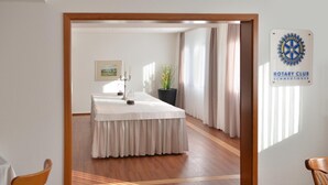 Una habitación con una mesa larga, una planta en maceta y un letrero que indica un Club Rotario.