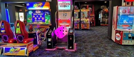 A gaming arcade with various machines including a 'Shoot Targets' game and a 'Monopoly' game.