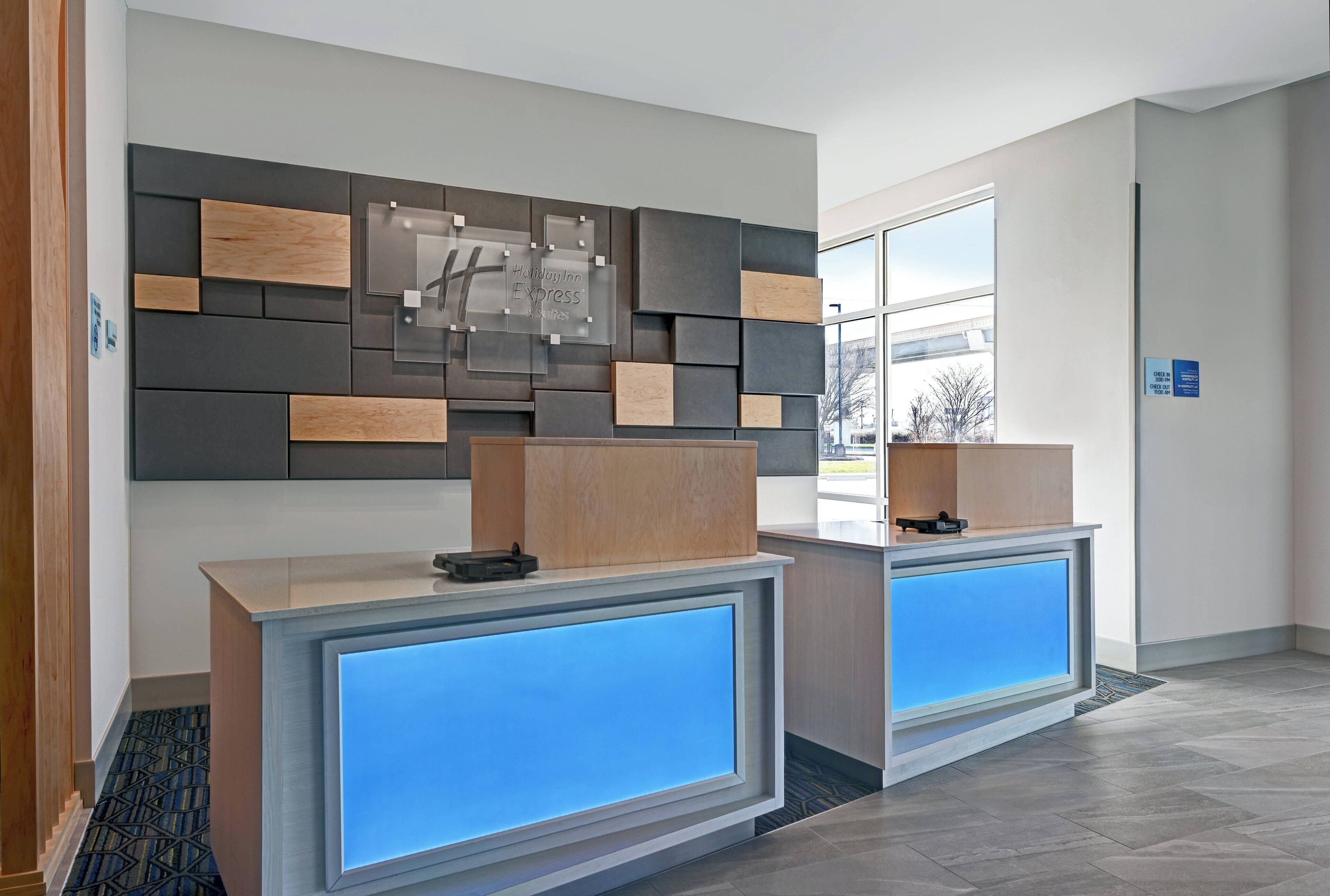 A reception desk with a modern design, a digital display, and a sign for Holiday Inn Express & Suites.