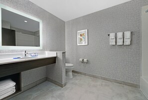 A modern bathroom with a large mirror, a sink, a toilet, and a towel rack. - Holiday Inn Express & Suites Houston - Memorial City Centre by IHG (Houston)