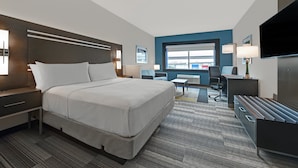 Een moderne hotelkamer met een groot bed, een bureau, een stoel en een televisie.