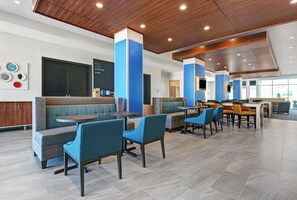 A modern restaurant with booths and tables, wooden ceiling, and a blue accent wall. - Holiday Inn Express & Suites Houston - Memorial City Centre by IHG (Houston)