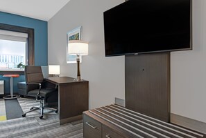 A hotel room with a desk, chair, TV, lamp, and a large window. - Holiday Inn Express & Suites Houston - Memorial City Centre by IHG (Houston)