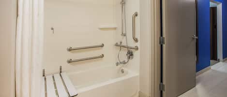 Un baño moderno con cabina de ducha, barras de apoyo y bañera.